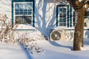 Heat pump outdoor unit freezing up in winter in Mount Holly NC: outdoor heat pump unit installed beside a home in snowy